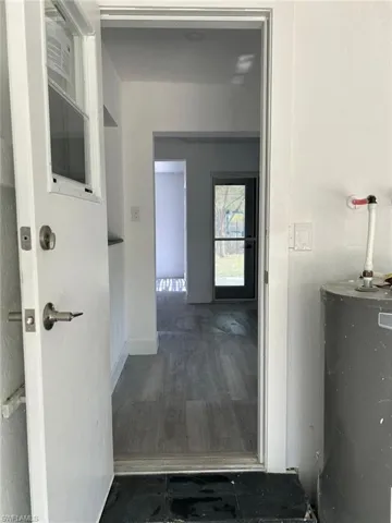 Hallway featuring water heater and dark wood-style floors