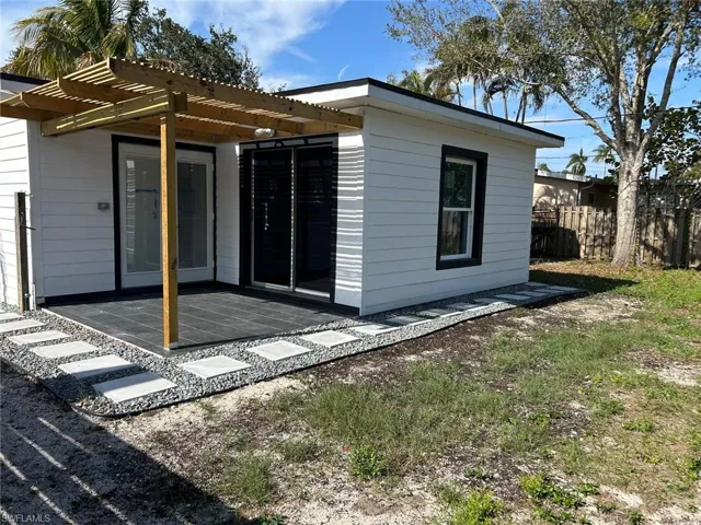 Rear view of property featuring a patio area and a pergola