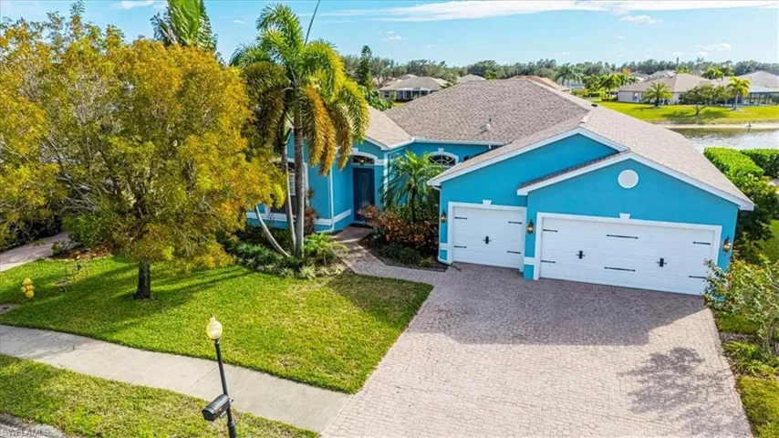 View of front of house featuring a front yard, decorative driveway, stucco siding, and a garage