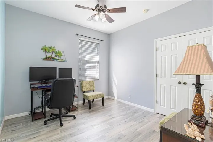 Office space with light wood-style floors and ceiling fan