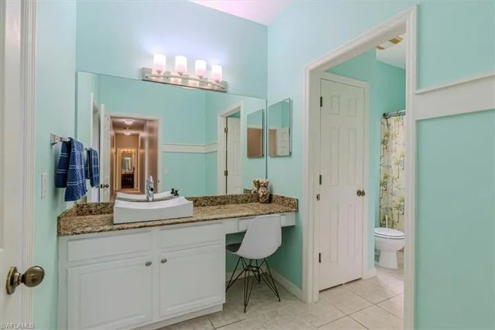 Full bathroom featuring a shower with shower curtain, vanity, and light tile patterned floors