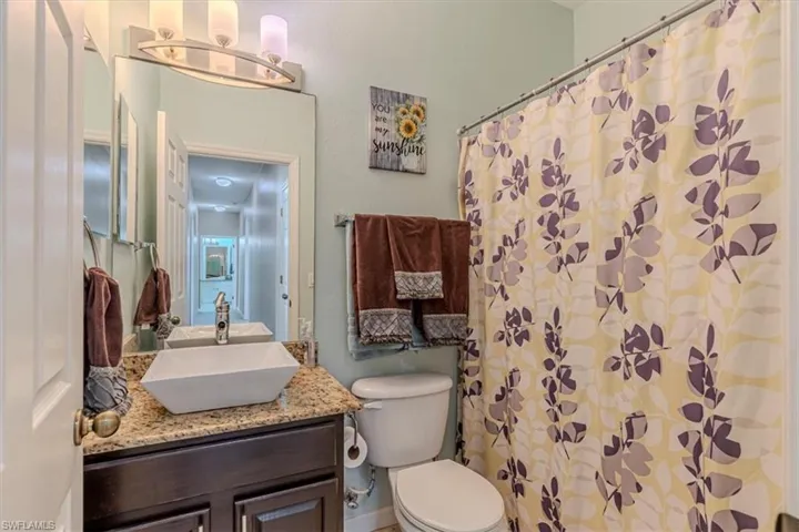 Full bathroom featuring a shower with shower curtain and vanity