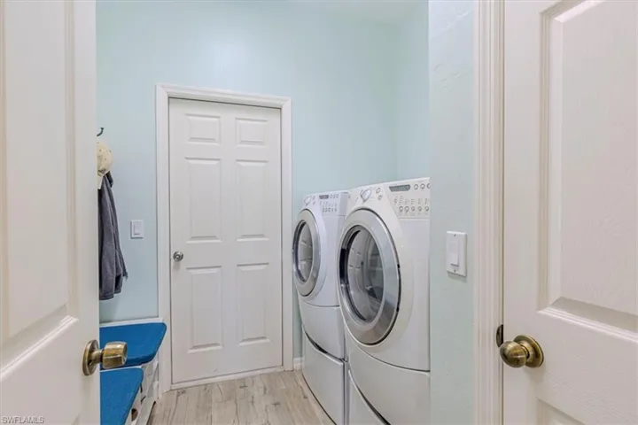 Laundry room featuring washing machine and dryer and light wood-style flooring