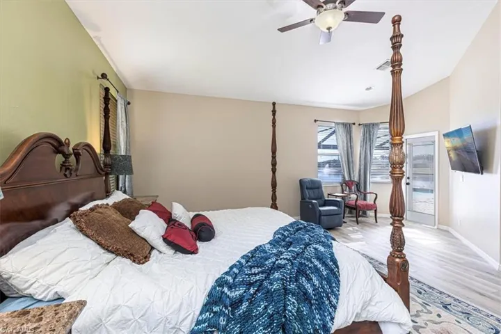 Bedroom with wood finished floors, a ceiling fan, and access to outside