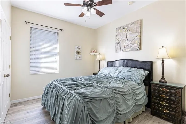Bedroom with light wood-type flooring, a closet, and a ceiling fan