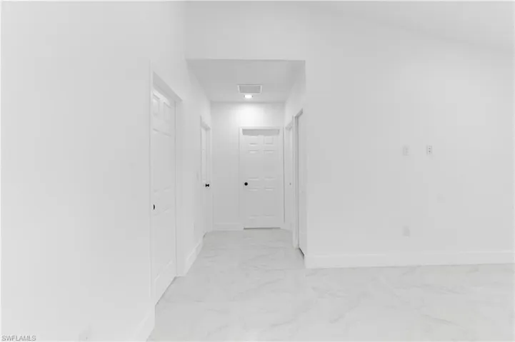 Corridor with baseboards and light marble finish floors
