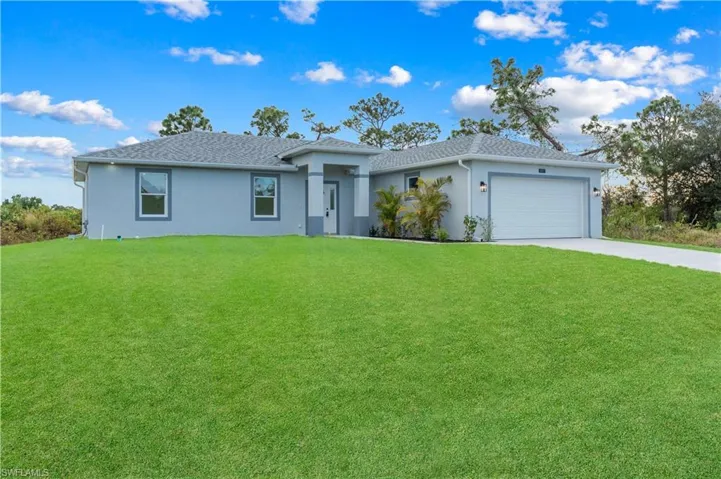 Ranch-style home with a front lawn, stucco siding, concrete driveway, an attached garage, and roof with shingles
