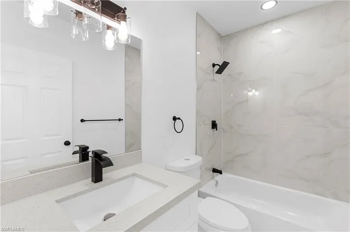 Bathroom with vanity, bathing tub / shower combination, and recessed lighting