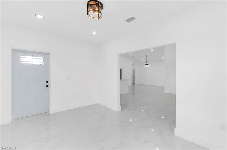 Entryway featuring light marble finish flooring, recessed lighting, and a chandelier