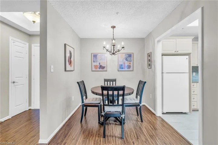 Dining room featuring a chandelier, a textured ceiling, and light wood-type flooring