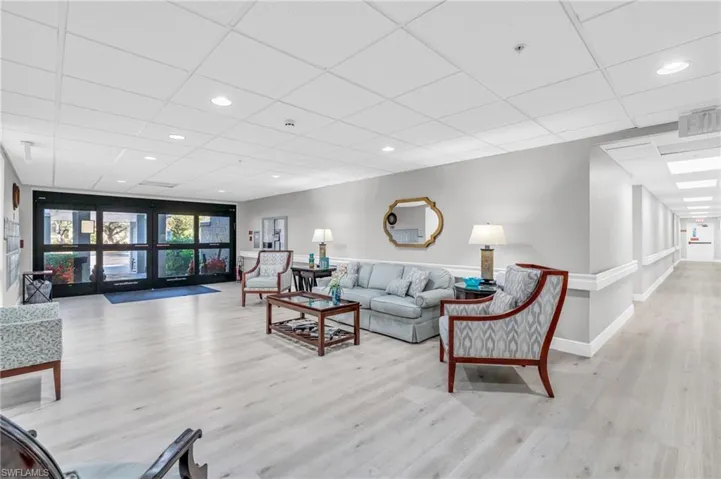 Living room featuring a drop ceiling and light hardwood / wood-style floors