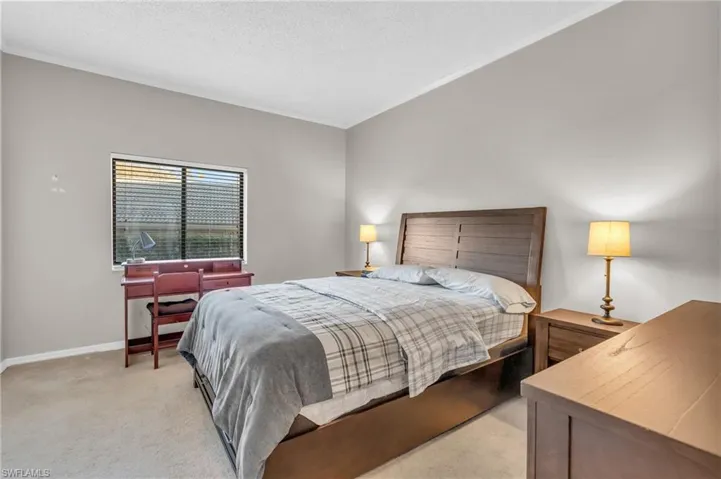 Carpeted bedroom with a textured ceiling and crown molding