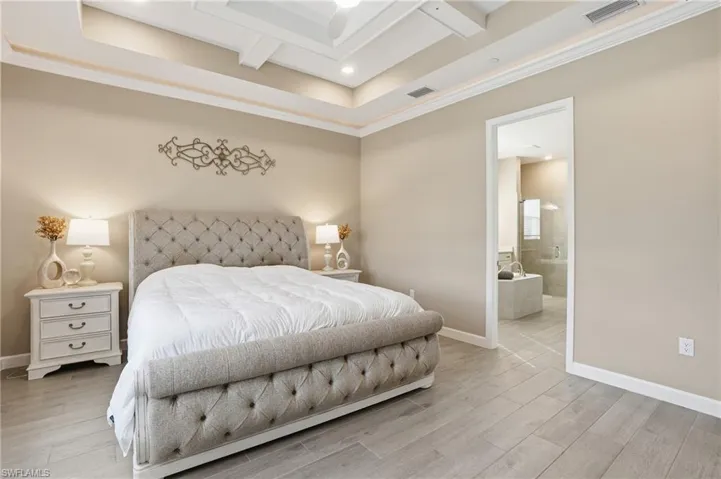 Bedroom with wood finish floors, ornamental molding, coffered ceiling, recessed lighting, and beam ceiling