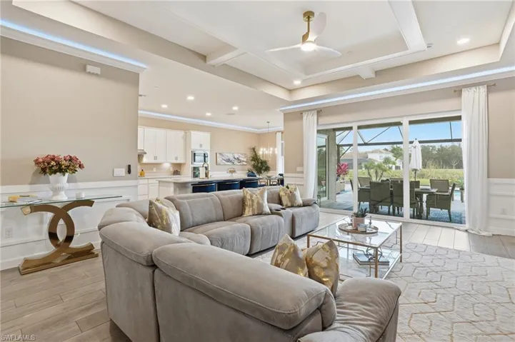 Living area with a wainscoted wall, a decorative wall, a ceiling fan, wood finish floors, and a sunroom