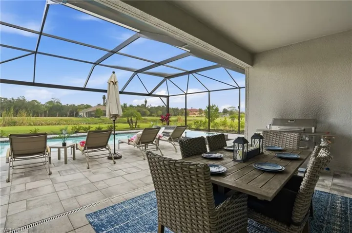 View of patio / terrace featuring a sunroom, a lanai, an outdoor pool, and outdoor dining area