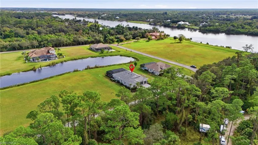 Aerial view of property's location with a large body of water and a forest
