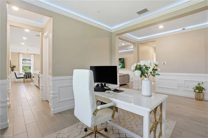 Home office with a wainscoted wall, wood finish floors, a decorative wall, and recessed lighting