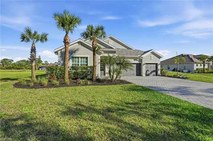 View of front of home with a front yard, decorative driveway, an attached garage, and stucco siding