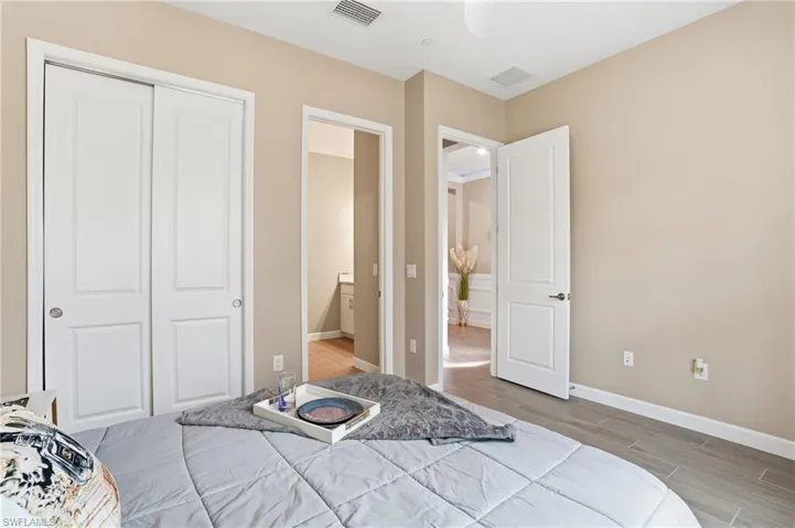 Bedroom featuring wood tiled floors and a closet