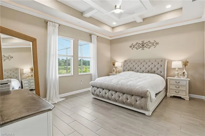 Bedroom with wood finish floors, coffered ceiling, beamed ceiling, crown molding, and ceiling fan