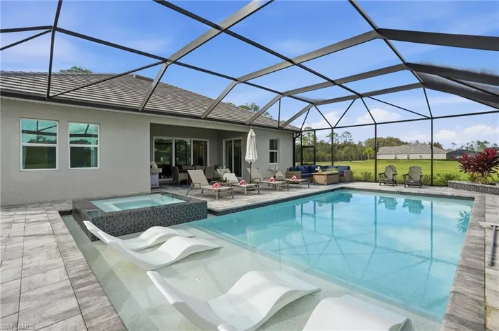 View of pool with a sunroom, an outdoor hangout area, a pool with connected hot tub, a patio area, and a lanai
