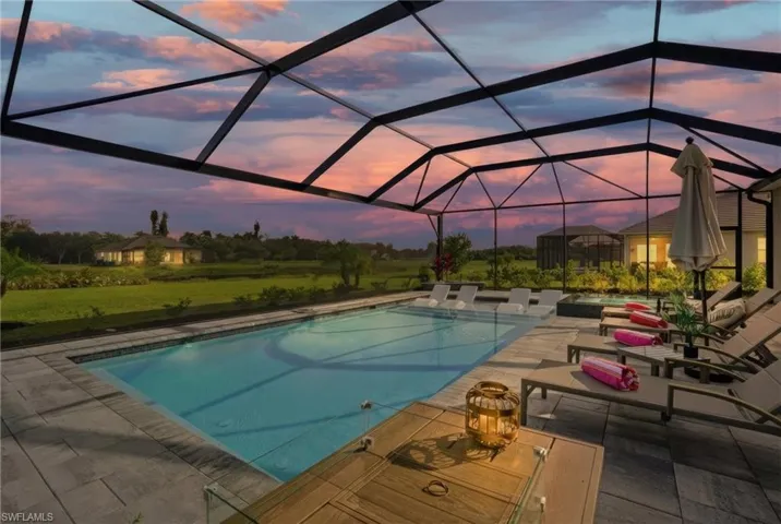 Outdoor pool with a jacuzzi, glass enclosure, a sunroom, and a patio