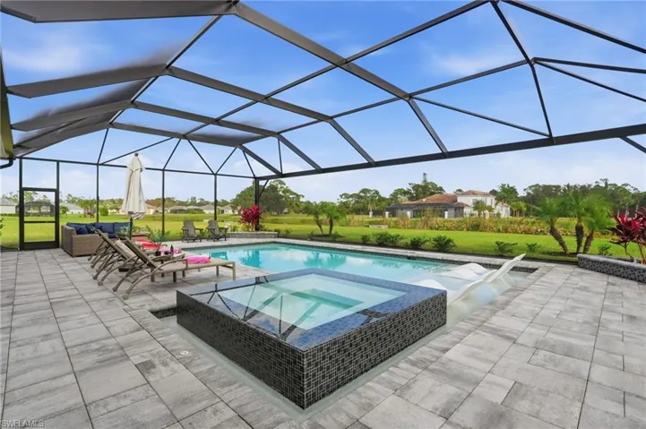 View of swimming pool with a sunroom, a lawn, a lanai, a patio area, and a pool with connected hot tub
