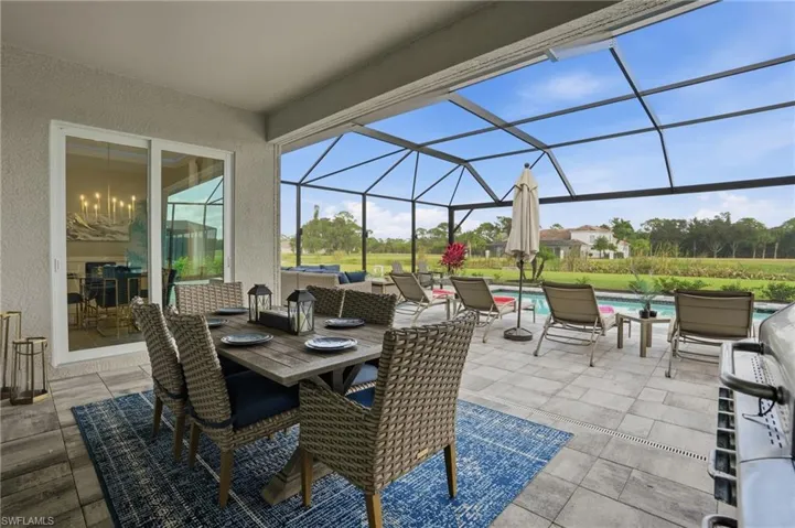 View of patio / terrace with an outdoor pool, a lanai, a sunroom, outdoor dining area, and grilling area