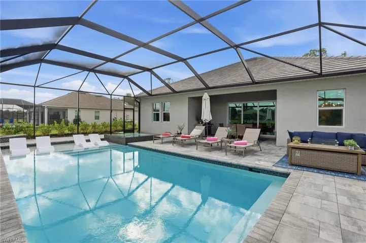 View of swimming pool with a sunroom, outdoor lounge area, a lanai, and a patio