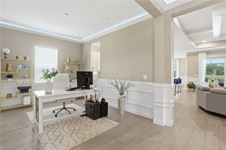 Office space with a decorative wall, wainscoting, light wood-type flooring, coffered ceiling, and beamed ceiling