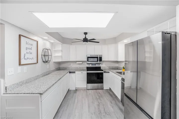 Kitchen with open shelves, a ceiling fan, white cabinetry, appliances with stainless steel finishes, and light wood-style flooring