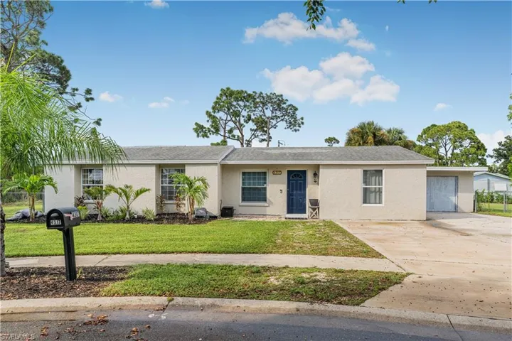 Single story home with a front yard, stucco siding, roof with shingles, and driveway