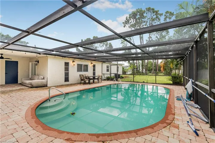 Outdoor pool featuring a yard, a lanai, and a patio area