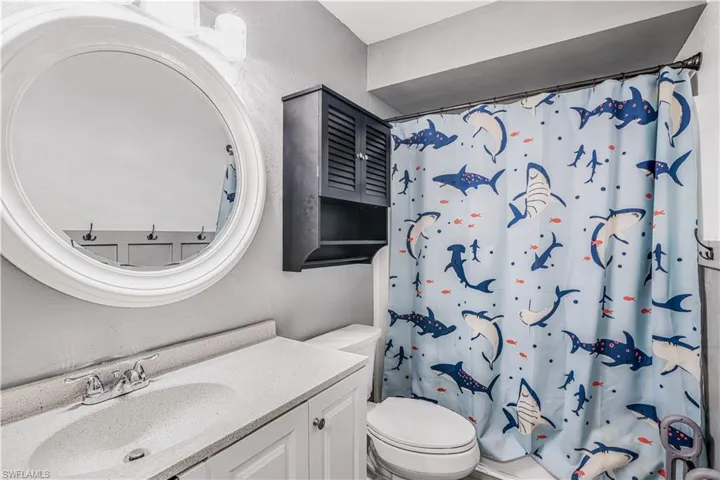Bathroom with a shower with curtain, toilet, and vanity