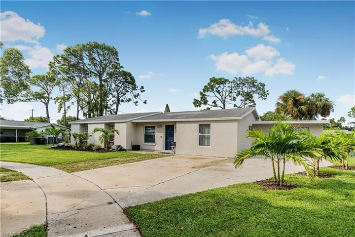Ranch-style home with stucco siding, concrete driveway, and a front yard