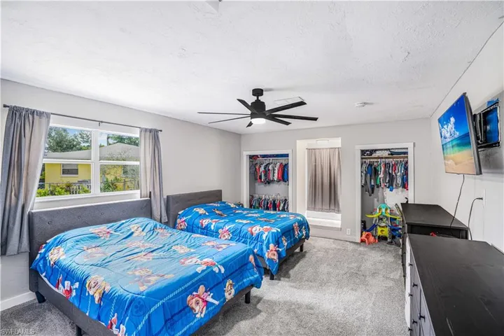 Bedroom featuring a textured ceiling, ceiling fan, and carpet