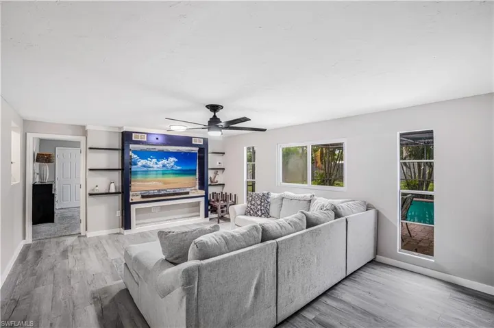 Living room with baseboards, wood finished floors, and ceiling fan