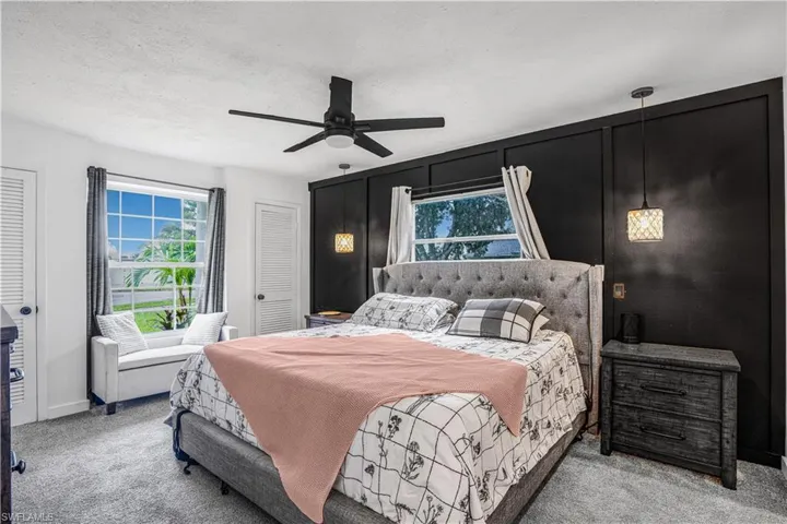 Carpeted bedroom featuring a closet, a textured ceiling, baseboards, and ceiling fan