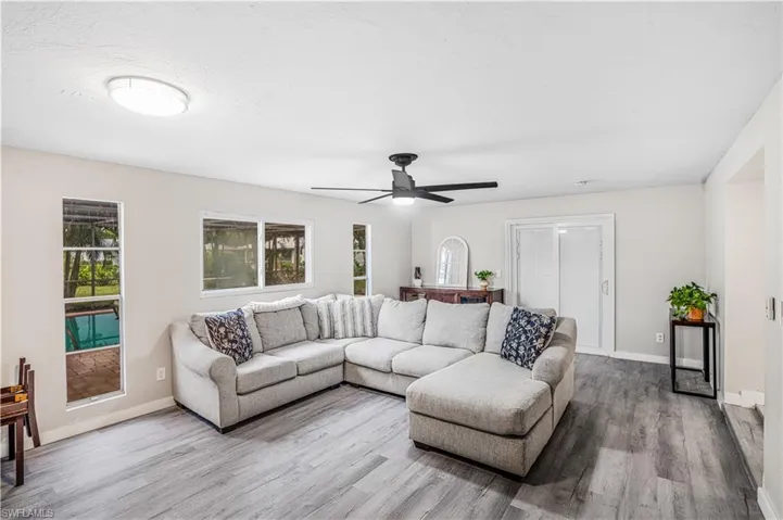Living area with baseboards, ceiling fan, and wood finished floors