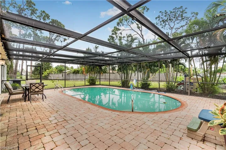 View of swimming pool with a patio, a fenced backyard, a fenced in pool, glass enclosure, and a yard