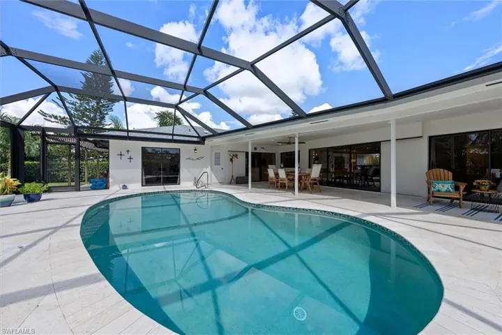 View of swimming pool with a lanai, ceiling fan, and a patio area
