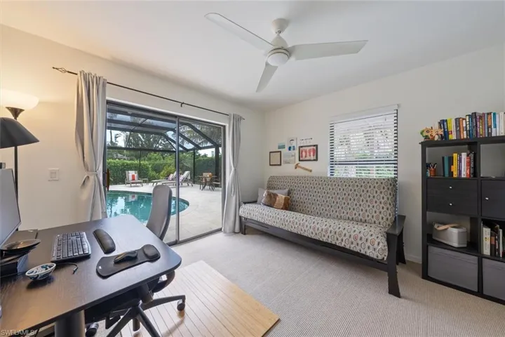 Home office featuring ceiling fan, light colored carpet, and a healthy amount of sunlight