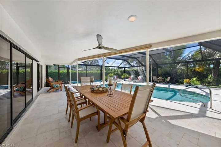 Sunroom / solarium with vaulted ceiling, a pool, and ceiling fan