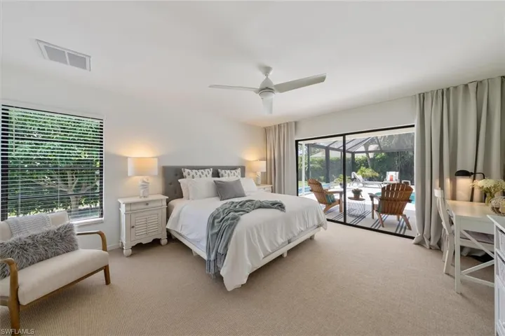 Bedroom featuring ceiling fan, light colored carpet, and access to exterior