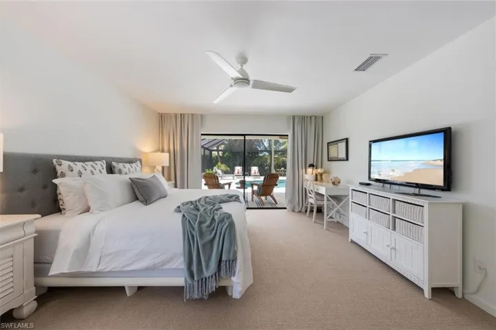Carpeted bedroom featuring ceiling fan and access to exterior