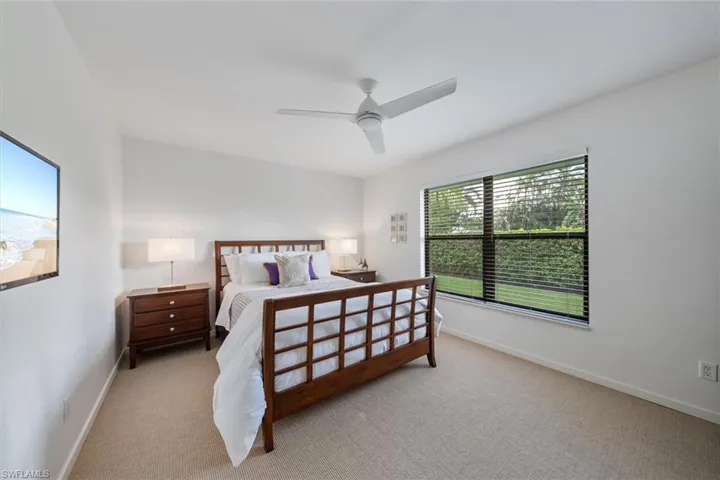 Bedroom with ceiling fan and light colored carpet