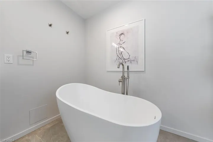 Bathroom with tile patterned flooring and a tub