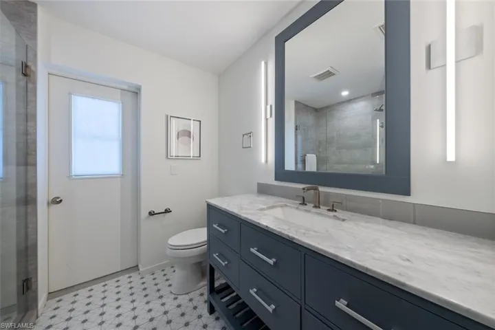 Bathroom with walk in shower, vanity, and toilet