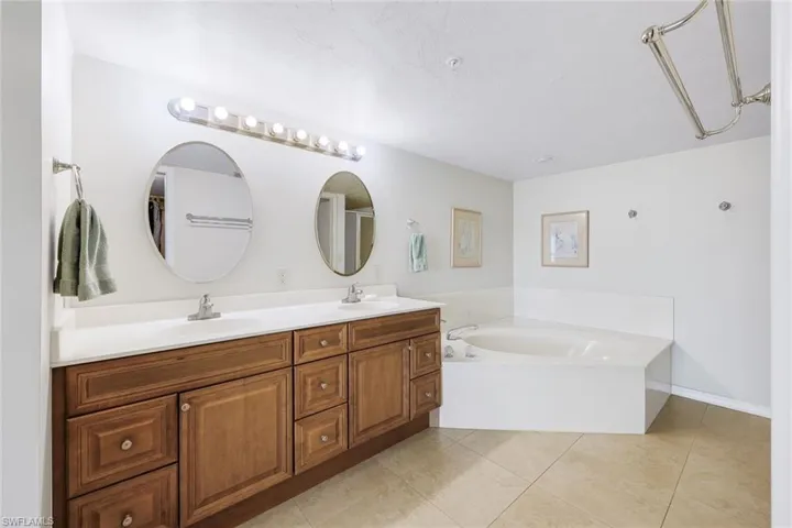 Serene primary bathroom with large jetted tub and a walk-in shower.