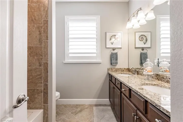 Bathroom with vanity, a tub, and toilet